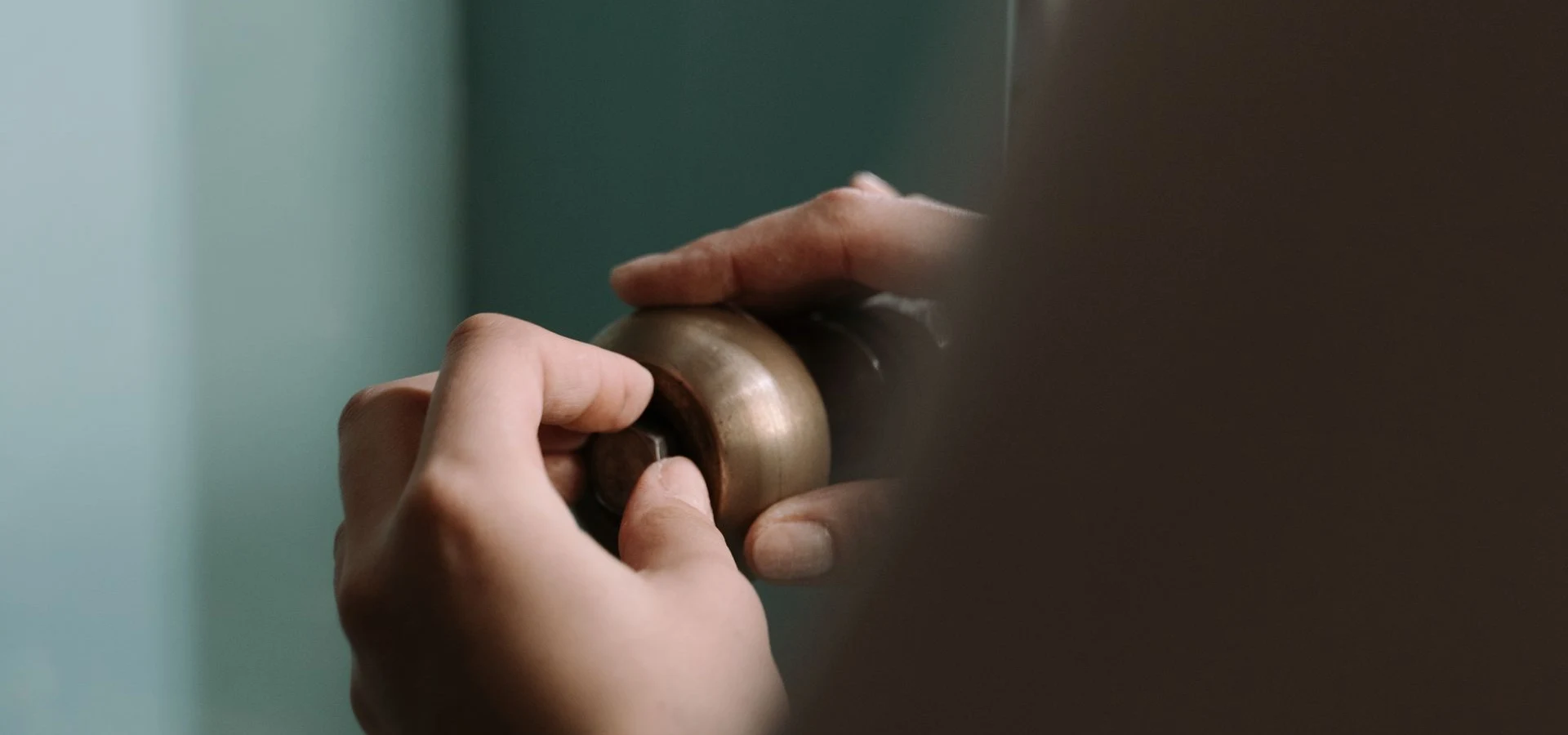 Close-up of hands turning a brass valve handle